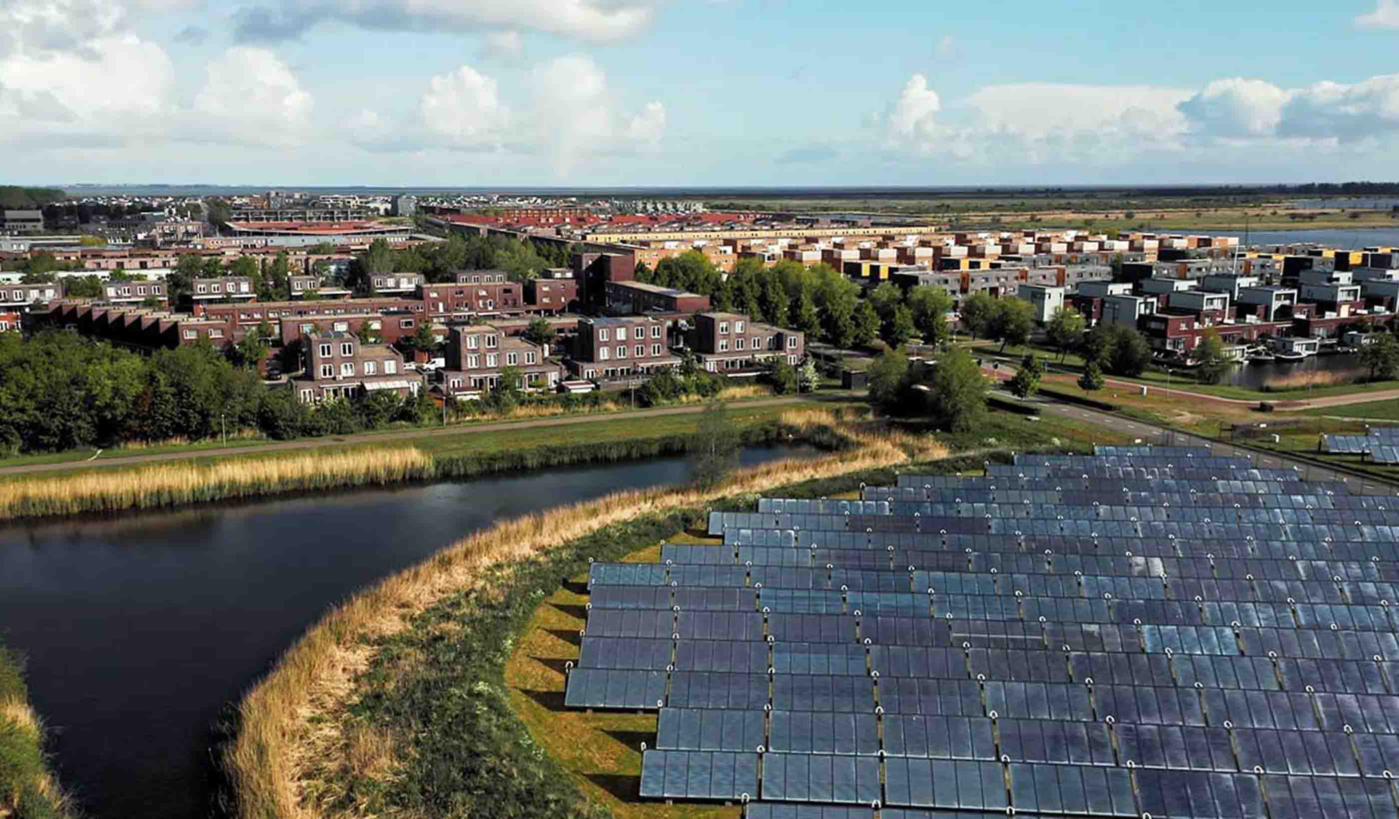 Aerial shot of a neighborhood with a solar panel field
