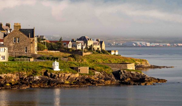 Landscape image of Shetland's inter-islands, showing houses and water.